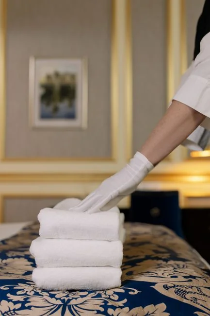 creative-01 Gros plan d’un professionnel en tenue de protection complète désinfectant une surface à l’intérieur.
